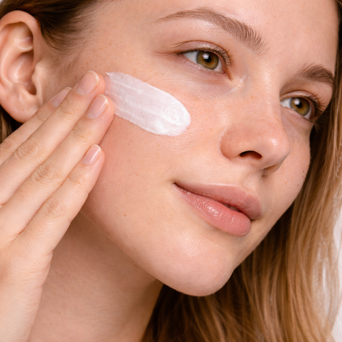 Model applying REVEA CALM Barrier Support Cream with Ceramides, Hyaluronic Acid and Ectoin for hydration and skin barrier support, suitable for sensitive skin.